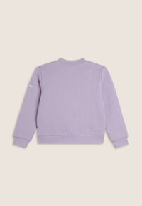 Sudadera acolchada color lavanda con cuello y puños acanalados, presenta costuras curvas sutiles y un parche con el logo en la manga izquierda.