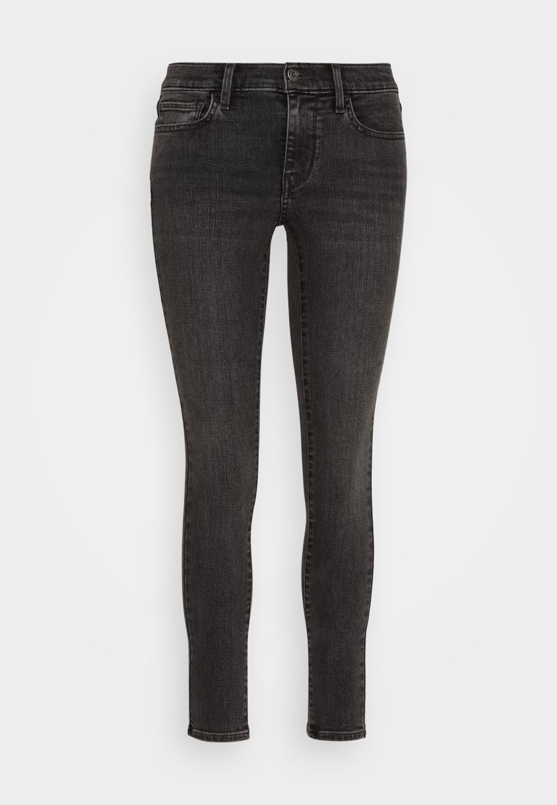 Jeans ajustados de mezclilla negra con un diseño clásico de cinco bolsillos, que presentan un cierre de botones y un leve desgaste para un aspecto texturizado.