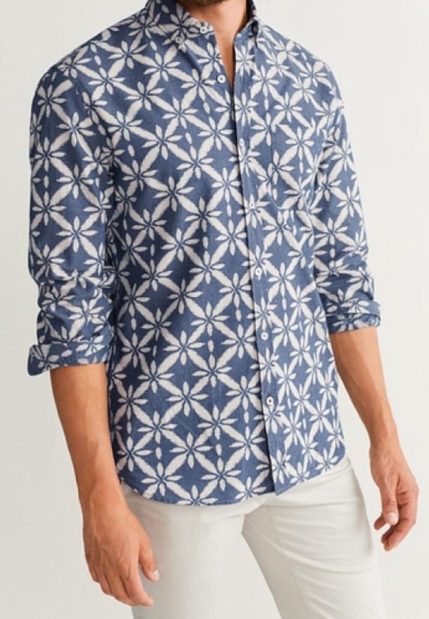 Camisetta a maniche lunghe con motivo floreale in blu navy e bianco, realizzata in tessuto intrecciato. Presenta maniche arrotolate e colletto classico.