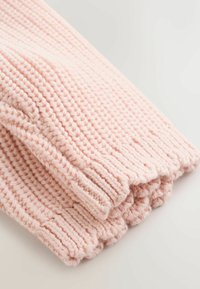 Bufanda de punto rosa claro suave doblada sobre una superficie clara que muestra una textura acanalada detallada.