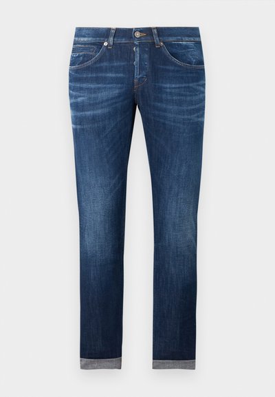 Dark blue slim-fit jeans with button fly, front pockets, and rolled cuffs displayed on a plain background.