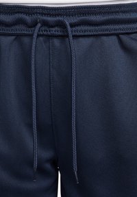 Navyblaue Jogginghosen mit einem elastischen Bund und verstellbaren Kordeln, glatter Textur und seitlichen Nähten für einen lässigen Look.
