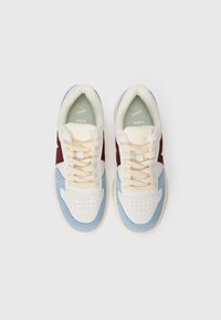 White, blue, and burgundy sneaker with a textured toe, round laces, and perforations on the toe box; padded tongue and mesh lining.