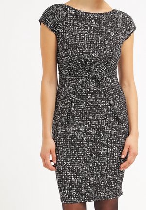Schwarz-weiß gemustertes Kleid mit figurbetonter Form, kurzen Kappenärmeln und einem geknoteten Taillendetail. Glatte Textur, knielanges Design.