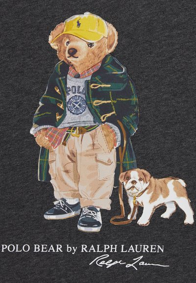 Grafik av en björn som bär en grön och rutig kappa, grå tröja, khakifärgade byxor och en gul keps, med en liten hund bredvid sig på en mörk bakgrund.