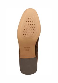Suela de zapato de ante marrón con un fondo de goma texturizada. Presenta pequeñas perforaciones, con "GEOX" y "PATENTE ITALIANA" embellecidos en la superficie.