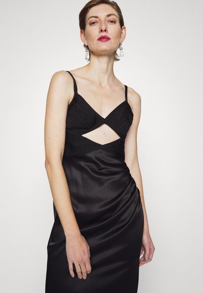 Fekete selyemruha vékony pántokkal, egyedi kivágással a mell alatt. Az anyag sima, az alja sűrített szoknyával rendelkezik.