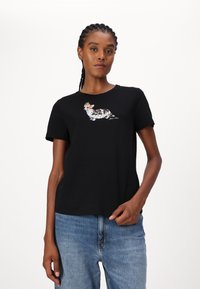 Zwarte katoenen t-shirt met een kleurraf corgi-graphic op de voorkant. Korte mouwen en een relaxte pasvorm. Draag het met lichtblauwe jeans.