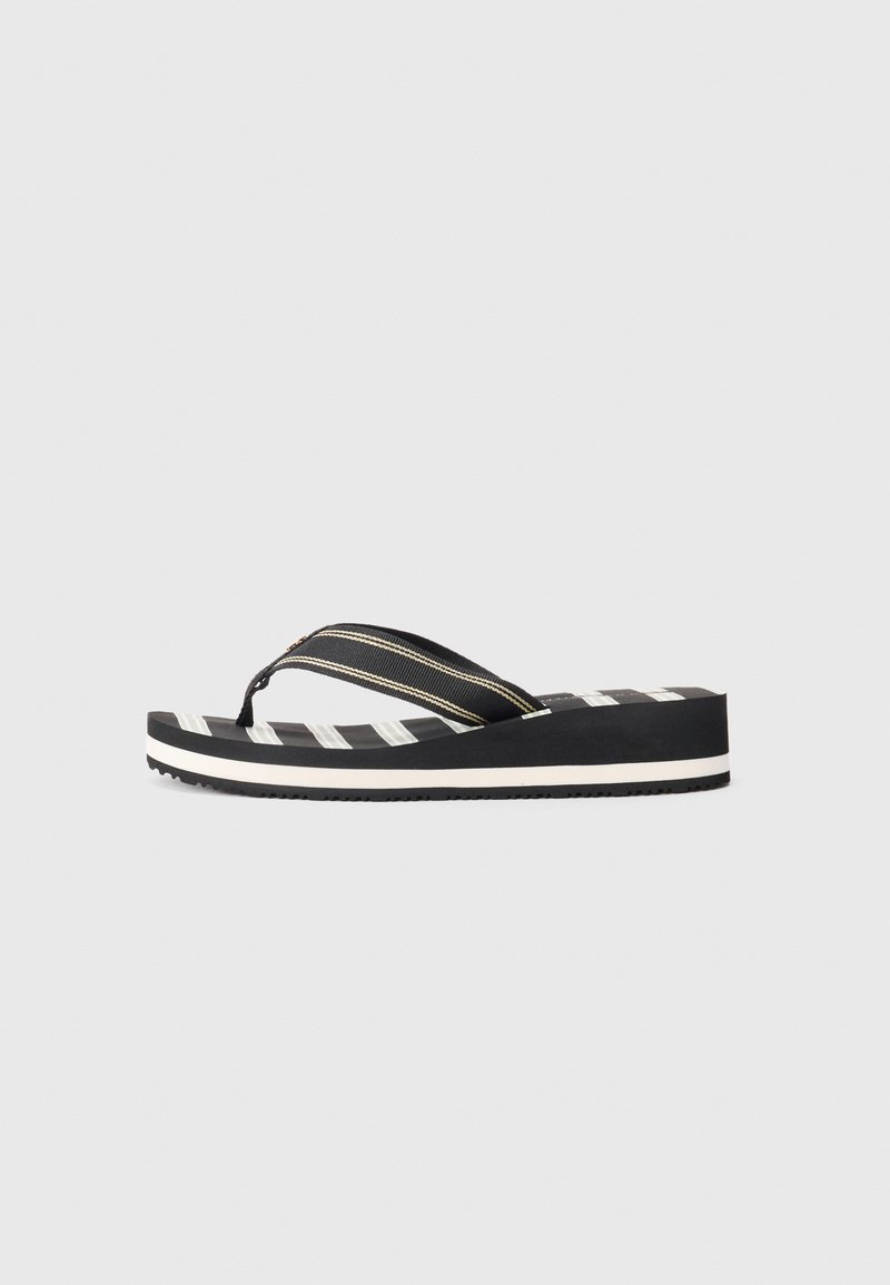 Juoda ir balta dryžuota platformos šlepetė su audinio tarpumi ir tekstūruota padas ant vienodo fono.