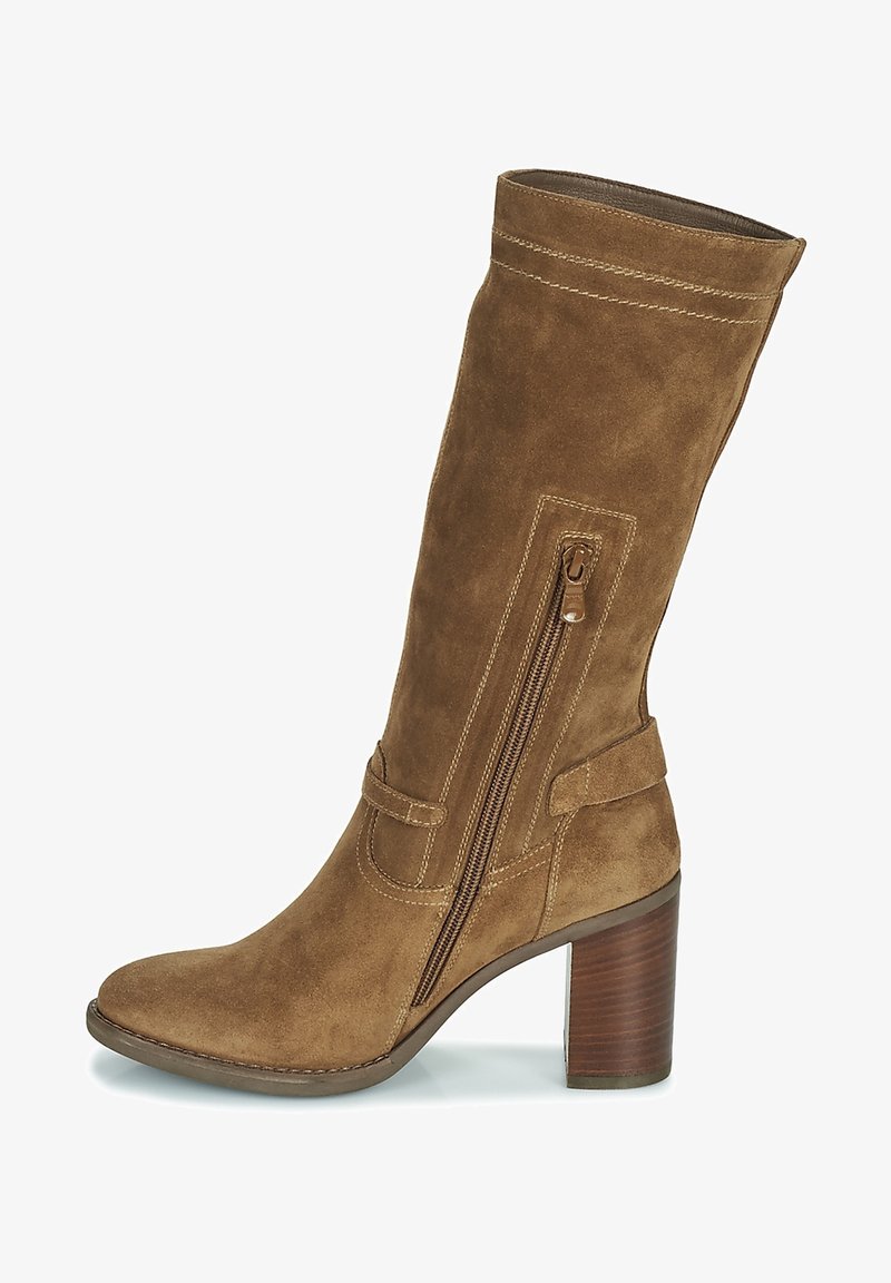Botte haute en daim marron avec une tige incurvée, une fermeture éclair latérale, des coutures décoratives et un talon épais en bois. Elle présente une texture lisse et douce.