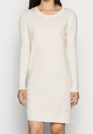 Robe en tricot crème à manches longues et coupe ample avec un col et des poignets côtelés, fabriquée dans un tissu doux et texturé.