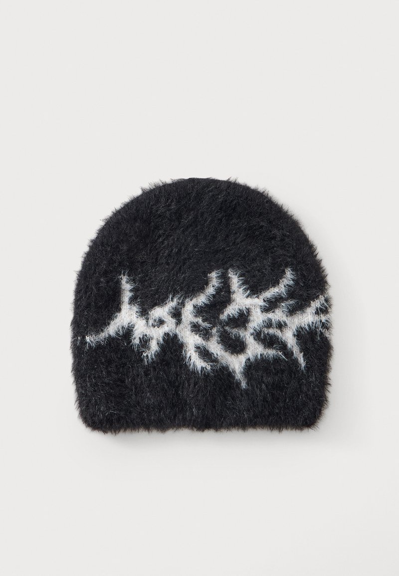 Bonnet noir pelucheux avec un motif d'éclair blanc sur le devant sur un fond clair uni.