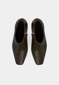 Brune krokodillemønstret lær ankelstøvler med spiss tå og sølvglidelåsdetaljer, med en glatt tekstur og slank design.