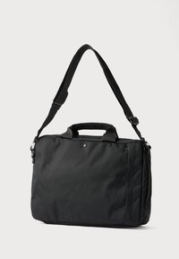 Juoda pirkinių rankinė, pagaminta iš tvirto audinio, su dviem viršutinėmis rankenomis, reguliuojamu petnešos diržu ir lygiu, matinio paviršiaus apdaila.