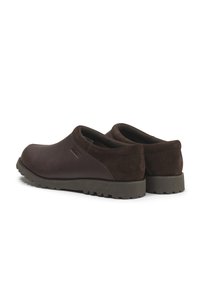 Chaussures en cuir marron et en daim avec une forme arrondie, un profil bas et une semelle texturée. Design simple sans quincaillerie ni accents visibles.