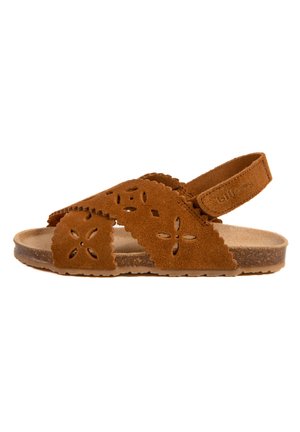 Sandale en daim marron avec des motifs floraux découpés, sangle de cheville réglable et semelle intérieure rembourrée, équipée d'une semelle texturée et flexible.