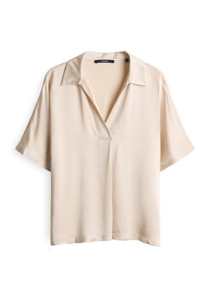 Blouse beige à manches courtes en tissu lisse, dotée d'un col cranté et d'une coupe décontractée. L'avant présente un décolleté en V discret.