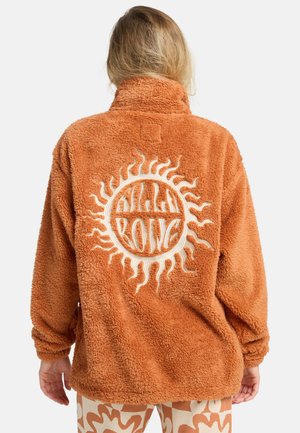Oranje fluffy fleec jacket met een hoge kraag, voorzien van een opvallende witte zonprint op de achterkant. Casual, oversized pasvorm.