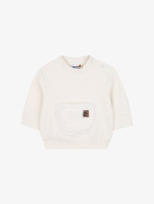 Felpa corta a maniche corte color crema realizzata in tessuto morbido, con una tasca in pile testurizzato e un piccolo logo applicato.