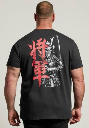 Homme portant un t-shirt noir avec des caractères japonais rouges et un guerrier samouraï blanc tenant une épée imprimée dans le dos.