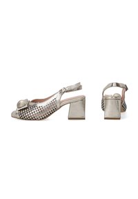 Metallic silver slingback shoes with a block heel, open toe, and cutout mesh design. Features a rounded accent at the front.
