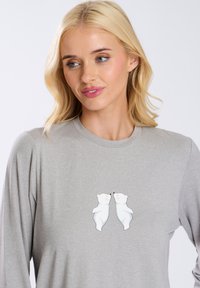 Camiseta de manga larga gris claro con un gráfico central de dos osos polares blancos. Tejido suave y diseño de cuello redondo.