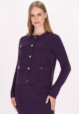 Purple knitted cardigan with a cable pattern, featuring gold buttons, two chest pockets, and a round neckline.