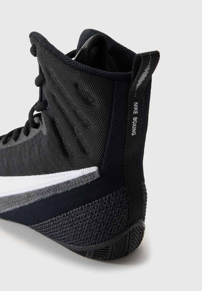 Boxingschuh aus schwarzem Mesh mit einer strukturierten Sohle. Verfügt über einen weißen Streifen in der Midsection und das Branding "NIKE BOXING" an der Ferse.