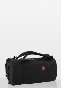 Sac de voyage en tissu noir de forme rectangulaire, doté d'une poignée supérieure, d'une bandoulière réglable et d'un détail de logo en relief.