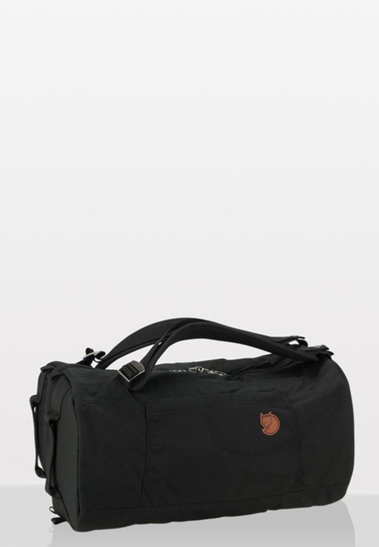 Sac de voyage en tissu noir de forme rectangulaire, doté d'une poignée supérieure, d'une bandoulière réglable et d'un détail de logo en relief.