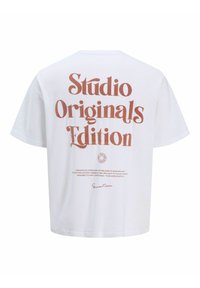 T-shirt blanc à manches courtes avec un grand texte marron « Studio Originals Edition » et un texte plus petit au centre du dos.