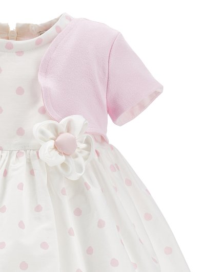 Otroška obleka s roza bolerom s kratkimi rokavi, belo krilo z roza pikami in belim tkaninskim cvetom z roza središčem na pasu.