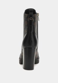 Stivaletti neri con tacco alto e alla caviglia, con un retro testurizzato, caratterizzati da un motivo con monogramma e chiusura con zip in metallo dorato.