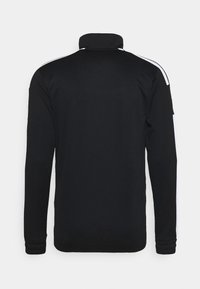 Chaqueta negra de manga larga con rayas blancas a lo largo de los hombros y las mangas, cuello alto, vista desde atrás.