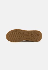 Suela de zapato de goma marrón con patrones texturizados, ventilaciones circulares y ranuras distintas para tracción; marcada con "GEOX."