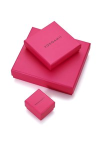 Drei pinkfarbene Geschenkboxen in unterschiedlichen Größen mit matter Oberfläche, auf deren Oberseiten das Logo "YOKOAMii" in Schwarz gedruckt ist.