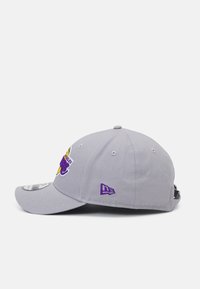 Gray baseball cap with a curved brim and embroidered purple logo. Features a textured fabric and snapback closure on the back.