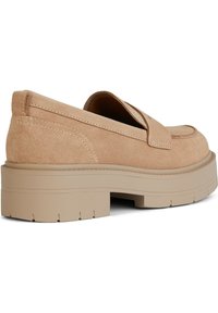 Mocassini beige in suede con una suola in gomma spessa e testurizzata. Il design presenta un accento cucito lungo la parte superiore e una forma arrotondata.