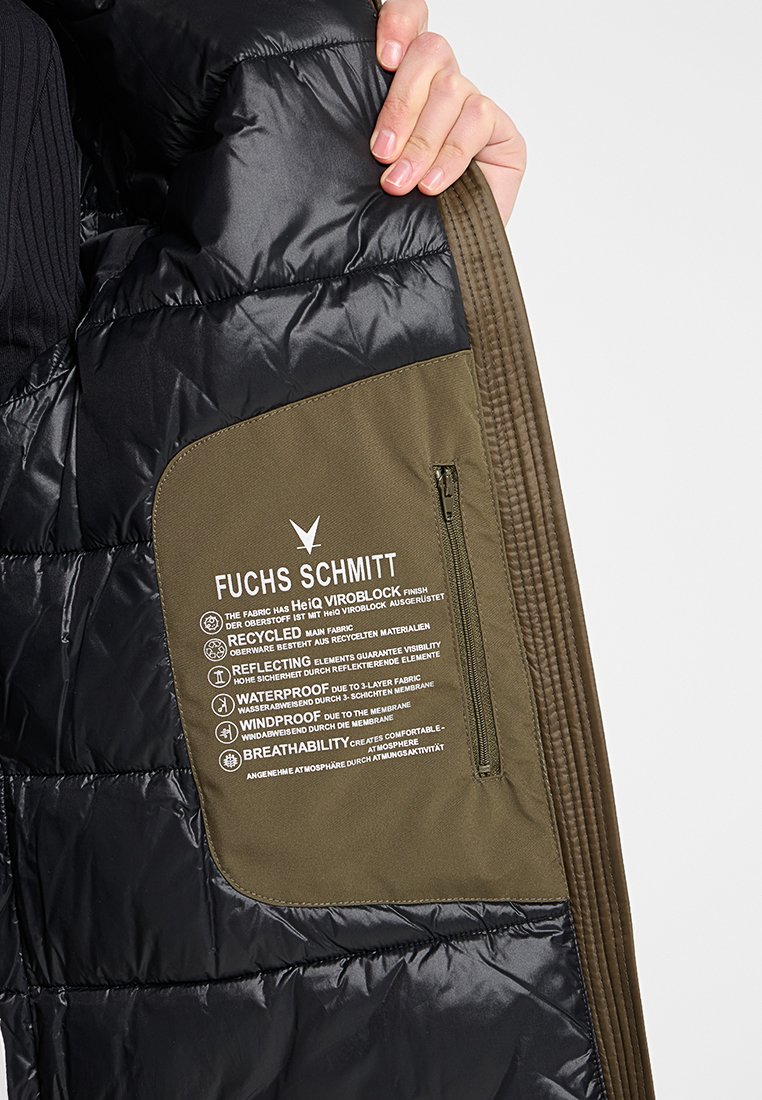 Doublure d'une veste en doudoune noire avec un panneau en tissu vert. Comprend une poche zippée et des détails textuels sur les matériaux imperméables et coupe-vent.