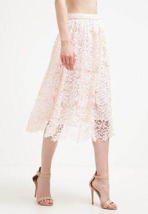Lace midi rok in lichtroze, met een bloemenpatroon, elastische tailleband en gegolfde zoom, gecombineerd met nude hoge hakken.