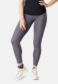 Grijze sportlegging met een gladde afwerking, voorzien van platte naden en een strakke pasvorm. Gecombineerd met meerkleurige sneakers met een dikke zool.