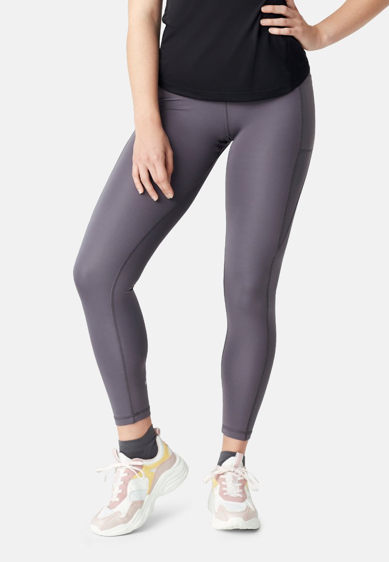 Grijze sportlegging met een gladde afwerking, voorzien van platte naden en een strakke pasvorm. Gecombineerd met meerkleurige sneakers met een dikke zool.