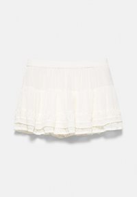 Mini-jupe blanche à volants superposés avec une taille élastique et des détails en tissu transparent sur les bords inférieurs.