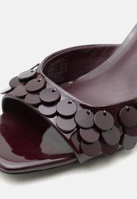 Σκούρο βουργουνδί ανοιχτό παπούτσι με στρώσεις στρογγυλών παγιετών που διακοσμούν το λουράκι στο μπροστινό μέρος.
