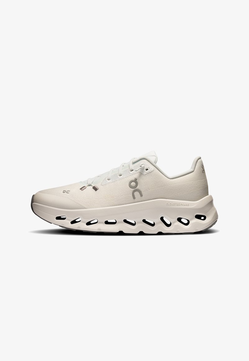 Scarpa sportiva grigia chiara con tomaia traspirante, una suola intermedia bianca spessa con aperture e una punta testurizzata per garantire durata.