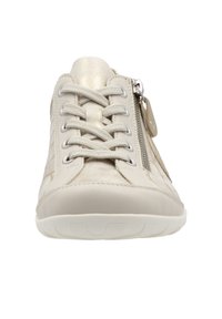 Baskets beiges avec lacets texturés, languette métallique, fermeture éclair latérale et semelle en caoutchouc blanche, vues de face sur un fond blanc.