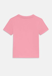 T-shirt rosa a maniche corte realizzato in cotone morbido. Presenta un colletto rotondo e cuciture senza soluzione di continuità. Design semplice senza grafiche o motivi.