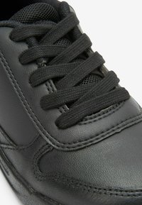 Basket en cuir noir avec des lacets noirs, un dessus texturé et des détails cousus. Le design comprend une languette rembourrée et des accents en mesh.