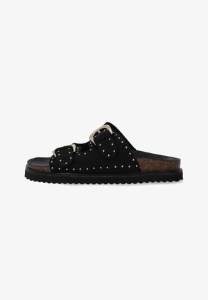 Czarne zamszowe klapki z dwoma regulowanymi klamrami, zdobione ćwiekami, z teksturowaną korkową wkładką i żłobioną gumową podeszwą.