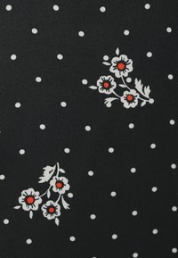 Μαύρο ύφασμα με λευκές πουά, με λουλουδένια σχέδια σε λευκό και κόκκινο. Ομαλή υφή, κεντρικά λουλουδένια μοτίβα και καθαρή αντίθεση.